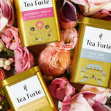 ゴージャスな花園の中に置いてある紅茶、ハーブティー、白茶のリーフティーギフト缶